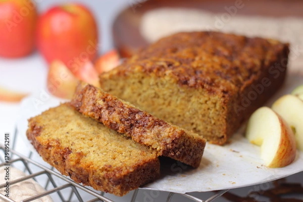 Fototapeta Apple cinnamon bread. Freshly baked loaf with slices cut, showing moist interior and golden crust
