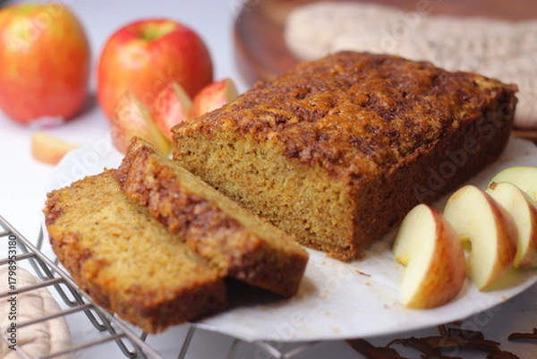 Fototapeta Apple cinnamon bread. Freshly baked loaf with slices cut, showing moist interior and golden crust