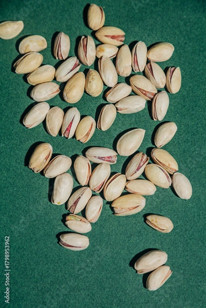 Obraz Salted pistachios in shells green background