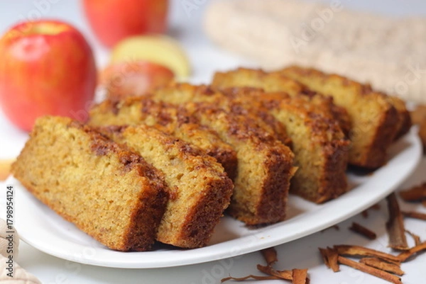 Fototapeta Apple cinnamon bread. Freshly baked loaf with slices cut, showing moist interior and golden crust