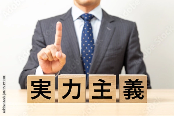 Fototapeta 「実力主義」と書かれたブロックとビジネスマン