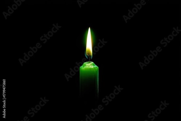 Obraz A green candle burns brightly with a warm, vivid flame against a stark, dark backdrop