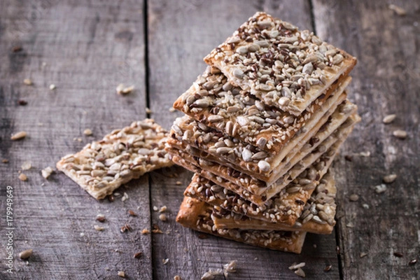 Obraz Crunchy crispbread on a wooden background. Healthy snack: cereal crunchy multigrain cereal flax seed ,sesame, sunflower seeds protein bread bar.