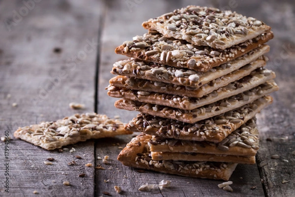 Obraz Crunchy crispbread on a wooden background. Healthy snack: cereal crunchy multigrain cereal flax seed ,sesame, sunflower seeds protein bread bar.