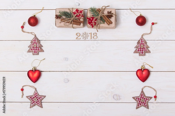 Fototapeta Concept christmas background with decorations, xmas tree and gift boxes on white wooden board. New year card. Empty space for your text. Sigh symbol from number 2018