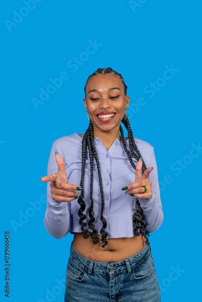 Obraz Young woman smiling and gesturing pointing in front