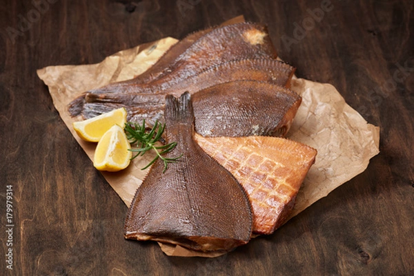 Fototapeta hot smoked beheaded flounder on the crumpled paper