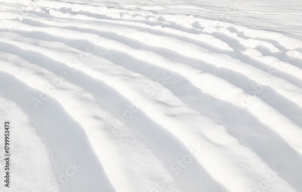 Fototapeta Winter background. An abstract pattern of deep curved furrows in the snow.