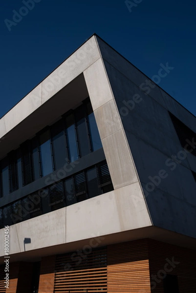 Fototapeta Minimalist Modern Office Building Corner with Concrete Facade and Wood Slat Base