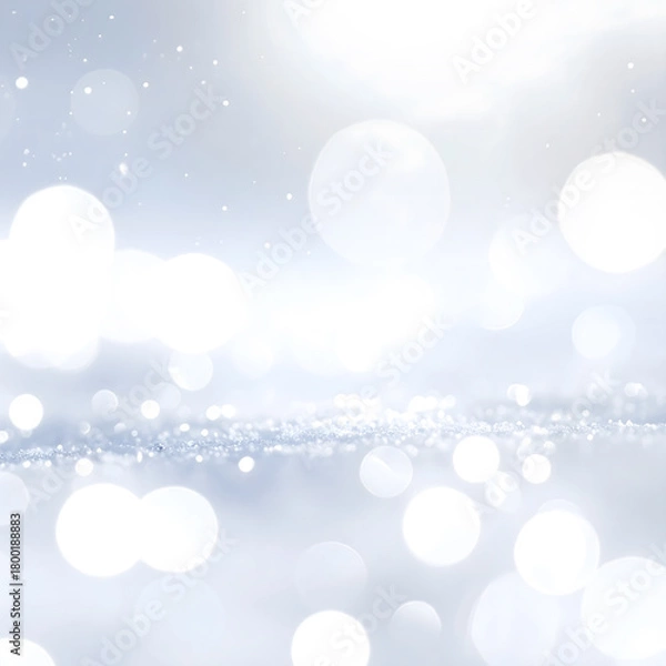 Fototapeta A soft bokeh background with shimmering white and silver lights. The scene evokes a festive atmosphere, perfect for New Year and Christmas celebrations.
