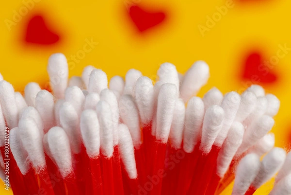 Obraz sticks with white cotton for hygienic procedures, red plastic sticks with natural white cotton at the ends for personal hygiene, close up