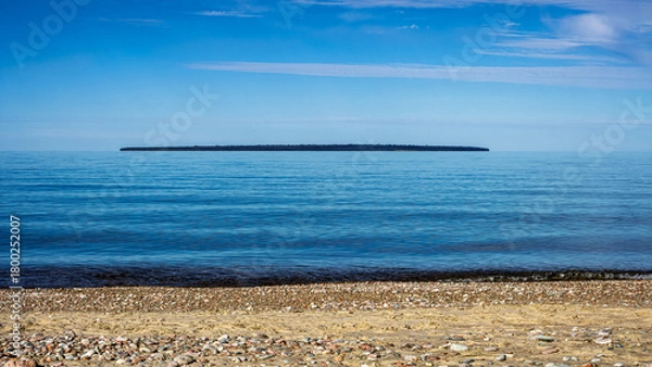 Obraz Montreal Island far out on horizon seen from Agawa Bay on calm Lake Superior, Ontario, Canada