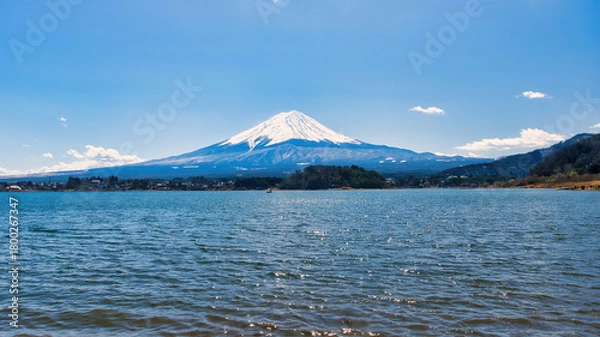 Fototapeta Lake Kawaguchiko, Japan - March 14 2025: Tourists enjoying the view of Lake Kawaguchiko with Mount Fuji in the background. Famous scenery of Mount Fuji in Japan. Blue skies on a cold sunny morning.