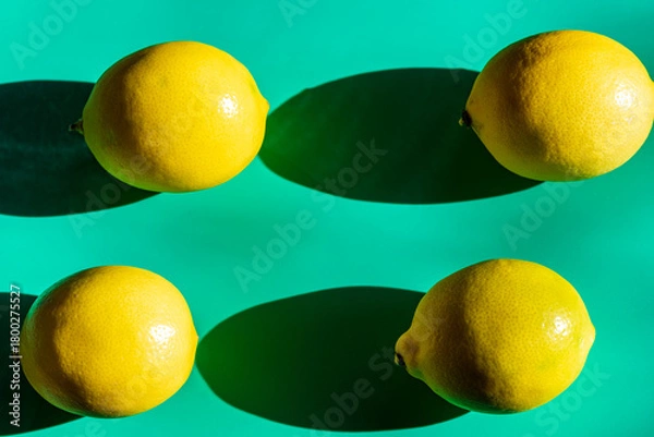 Fototapeta A vibrant yellow lemon resting on a table, captured in soft natural light. The image highlights the fruit’s bright color, fresh texture, and simple composition, making it suitable for food photography