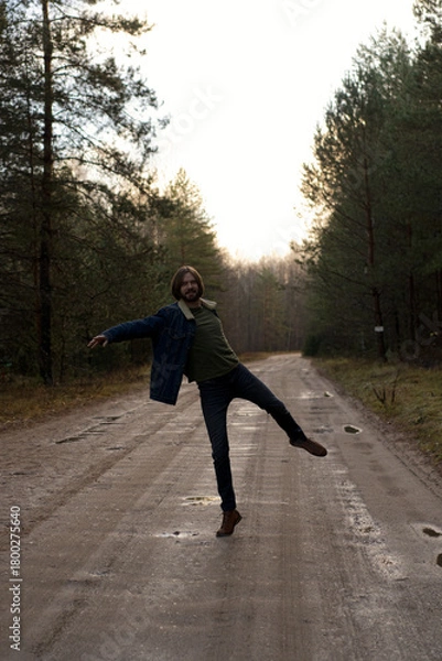 Fototapeta Man Dancing and Having Fun on Dirt Road Through Forest