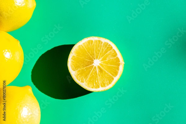 Fototapeta A vibrant yellow lemon resting on a table, captured in soft natural light. The image highlights the fruit’s bright color, fresh texture, and simple composition, making it suitable for food photography