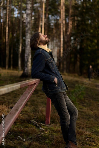 Fototapeta Man Enjoying the Outdoors, Leaning on Fence in Forest