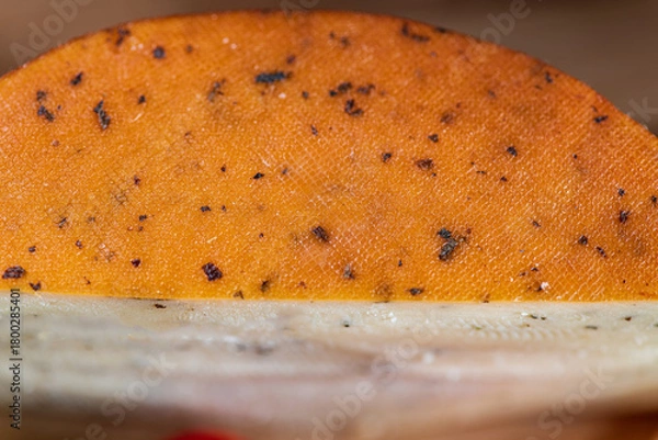 Fototapeta Slices of semi-hard cheese arranged neatly with fresh basil leaves on top. The combination of creamy-yellow cheese and vibrant green basil creates a clean, appetizing visual contrast.