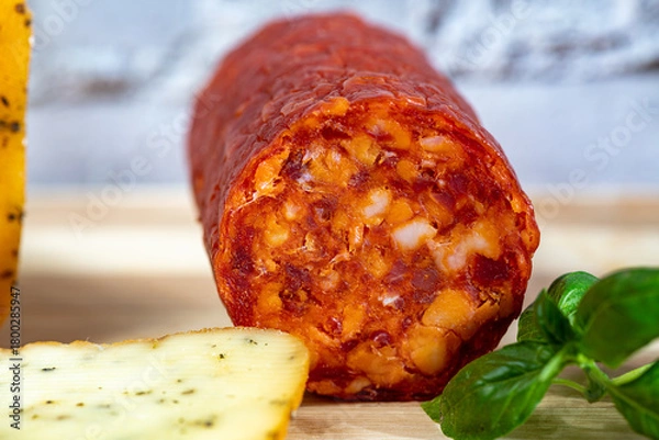 Fototapeta Thin slices of kulen arranged neatly on a plate, showcasing the rich red color and distinctive marbled texture of this traditional cured sausage. Soft natural lighting enhances the savory details and 