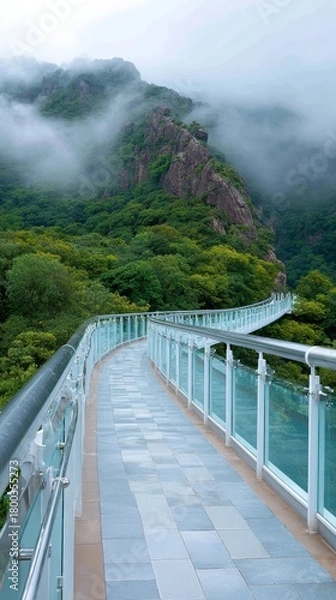 Obraz Scenic glass bridge winding through misty forested mountains