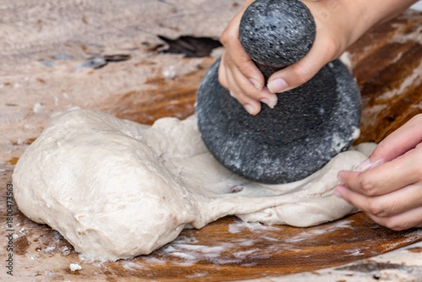 Fototapeta Poi or popoi is a traditional staple food in the Polynesian diet, made from taro.  Waiahole Poi Factory, Honolulu, Oahu, Hawaii. pounding taro / hand pound poi.