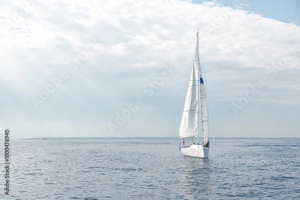 Fototapeta Sailboat sailing in the sea with sails up on a cloudy day