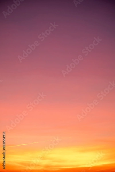 Fototapeta Sunset or sunrise sky with a vibrant gradient of orange, gold, and soft blue. Clear atmosphere with wispy clouds. Peaceful, natural light background. hope, freedom, new day Concepts, Vertical