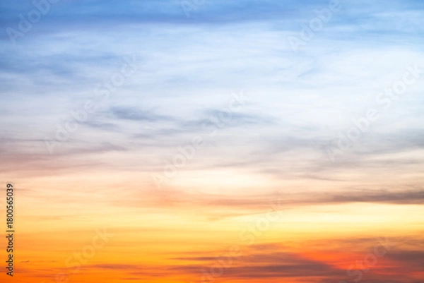 Fototapeta Sunset or sunrise sky with a vibrant gradient of orange, gold, and soft blue. Clear atmosphere with wispy clouds. Peaceful, natural light background. hope, freedom, new day and inspirational Concepts