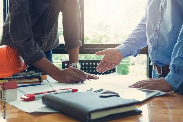 Fototapeta Engineer and Architect concept, Engineer Architects office team working and discussing house plan  model, Vintage Effect