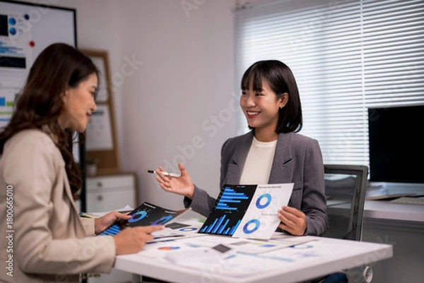 Fototapeta Businesswomen analyzing financial data, collaborating on business strategy