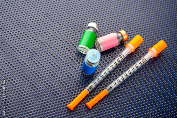 Fototapeta Single Use Syringes Next to Small Glass Vials