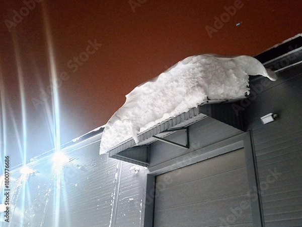 Obraz a snowdrift dangerously hanging from the roof. taken in winter
