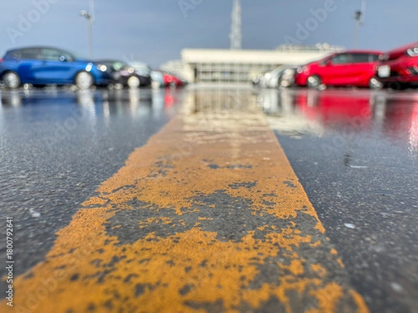 Fototapeta 雨上がりの駐車場、濡れた地面と自動車