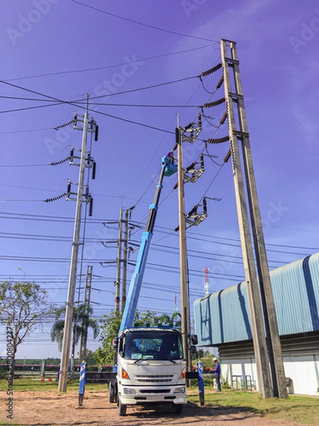 Fototapeta Maintenance service for high-voltage distribution systems, Electricity substation with blue sky backgound