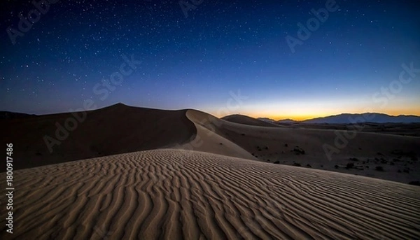 Obraz A serene desert scene under a starlit night sky, with undulating sand dunes in the foreground and mountains in distance