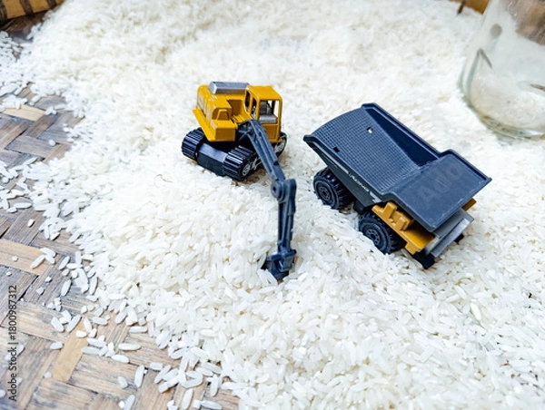 Fototapeta Toy Excavator and Dump Truck on White Rice Surface Playful Miniature Scene