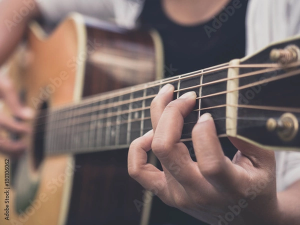 Fototapeta Closeup of the girl is playing acoustic guitar with sun flare and beautiful bokeh in the backyard