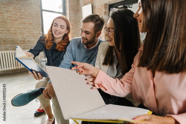 Fototapeta Interns laughing at their notes