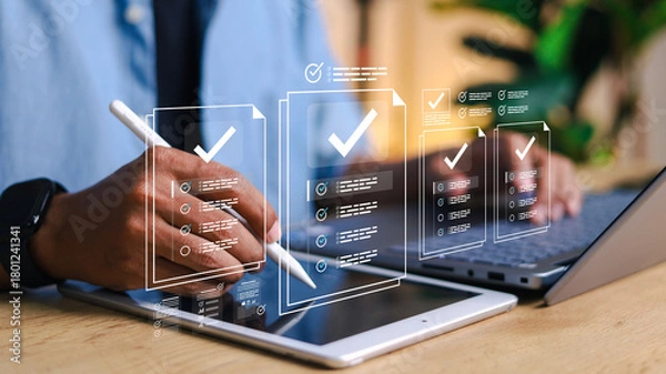 Fototapeta Person using digital tablet with stylus and laptop, with virtual checklist and task management interface overlay. Concept of productivity, workflow, digital forms, and online organization.