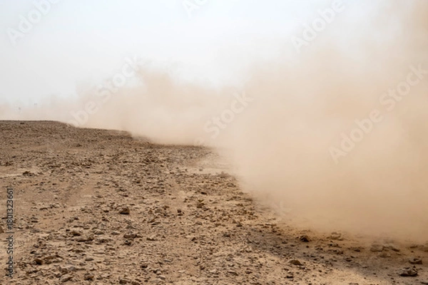 Fototapeta Zikreet, Qatar - November 15, 2025: A large storm formed, powdered dust and sand on the ground were blown into the clouds, causing the orange glow to look horrible. extreme weather events.