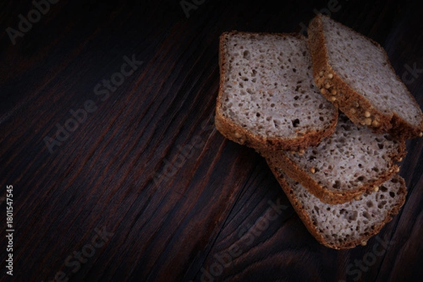 Fototapeta Sliced buckwheat bread on dark wooden background.
