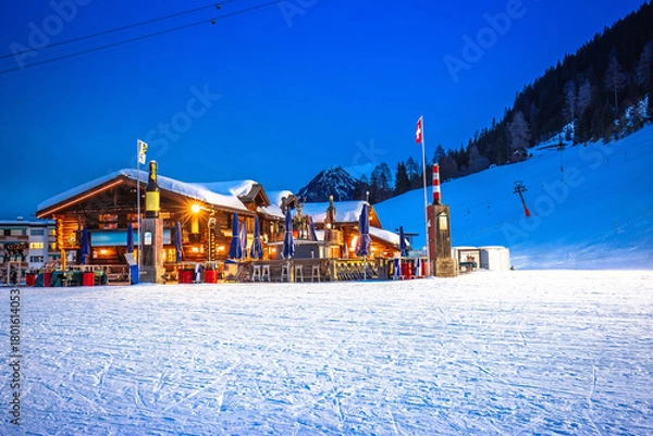 Obraz Idyllic mountain town of Davos in Swiss Alps ski slope and apres ski lodge evening view
