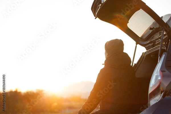Obraz 車のトランクを開け、朝日を眺める男性