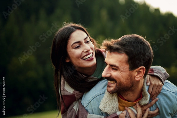 Obraz Happy couple enjoying piggyback ride in nature