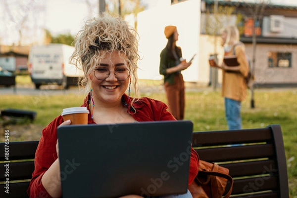 Obraz Student woman smiling working on laptop enjoying coffee outdoors
