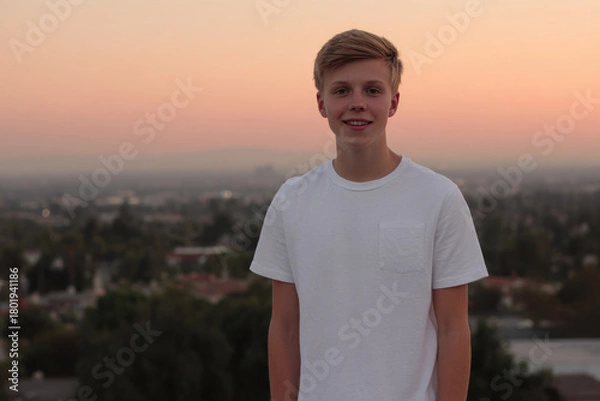 Fototapeta cheerful american teenager is beaming with happiness against backdrop of stunning sunset