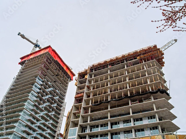 Obraz High rise monolith concrete buildings with the cranes above