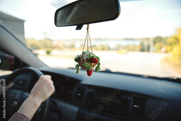 Obraz A dashboard hanger attached to the rearview mirror inside a small car.