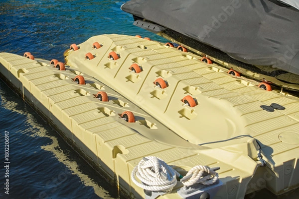 Obraz Close-up: Modular floating dock for personal watercraft (PWC) with a roller system for easy launch and retrieval. Warm lighting.
