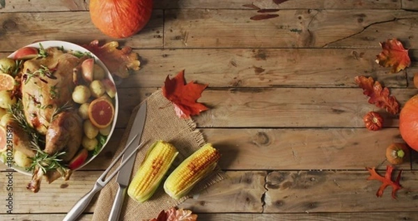 Fototapeta Displaying roasted turkey on platter sitting on home table, with carving fork, corn, copy space
